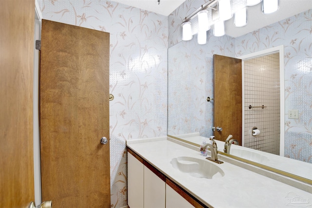 bathroom featuring vanity and wallpapered walls