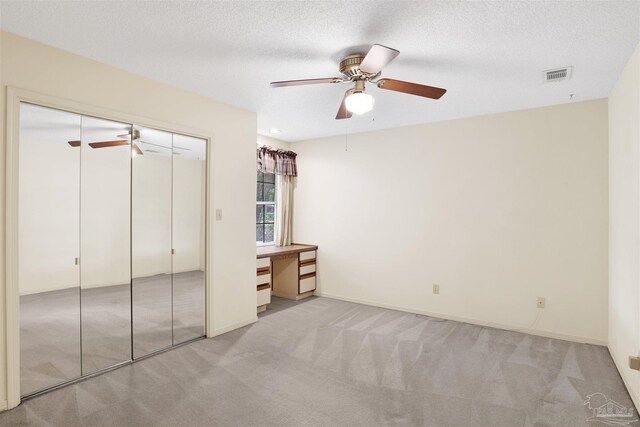 unfurnished bedroom with visible vents, carpet floors, a closet, and ceiling fan