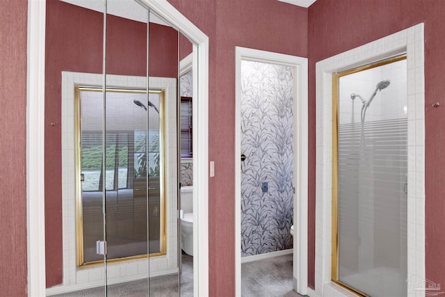 full bathroom featuring a stall shower, baseboards, and toilet