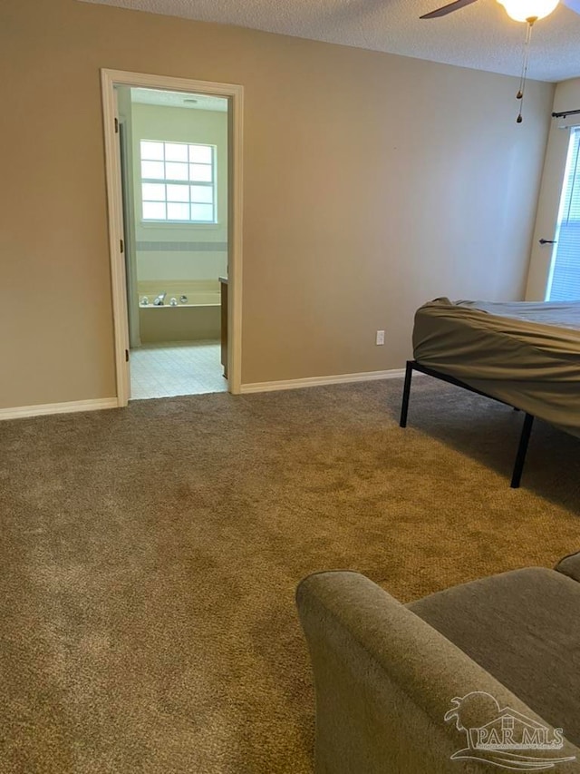 bedroom featuring ceiling fan, a textured ceiling, carpet floors, and ensuite bath