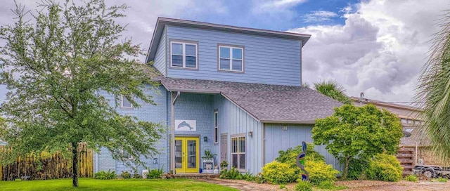 view of front of home with a front yard and french doors