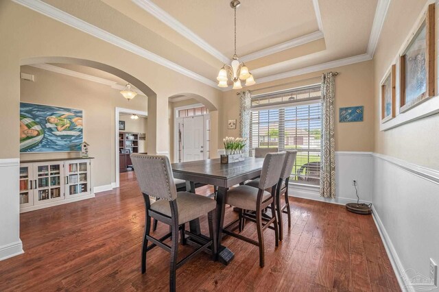 8847 Salt Grass Dr, Pensacola, FL 32526 - dining area featuring arched walkways, a chandelier, ornamental molding, and wood finished floors