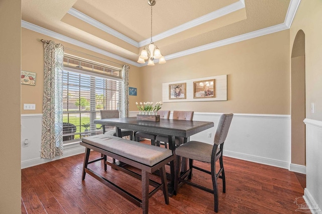 8847 Salt Grass Dr, Pensacola, FL 32526 - dining room featuring crown molding, wood finished floors, a raised ceiling, a chandelier, and arched walkways