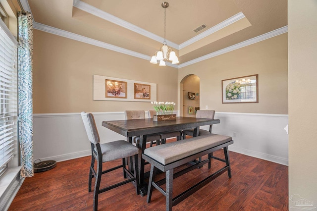 8847 Salt Grass Dr, Pensacola, FL 32526 - dining space with arched walkways, a raised ceiling, wood finished floors, and a notable chandelier