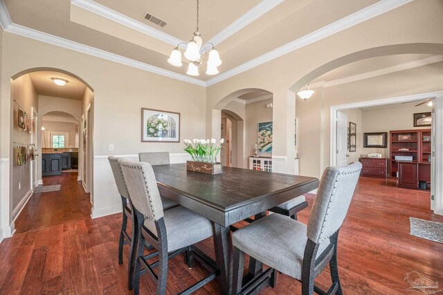 8847 Salt Grass Dr, Pensacola, FL 32526 - dining space with crown molding, a raised ceiling, dark wood-type flooring, and visible vents