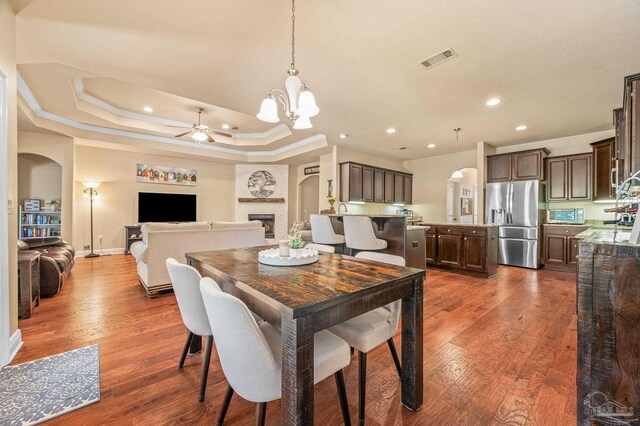 8847 Salt Grass Dr, Pensacola, FL 32526 - dining space with crown molding, dark wood-style flooring, arched walkways, ceiling fan with notable chandelier, and recessed lighting