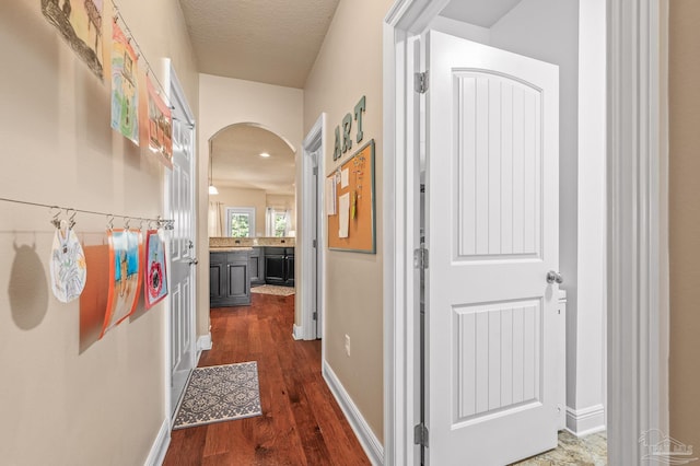 8847 Salt Grass Dr, Pensacola, FL 32526 - corridor featuring dark wood-style flooring, arched walkways, and baseboards