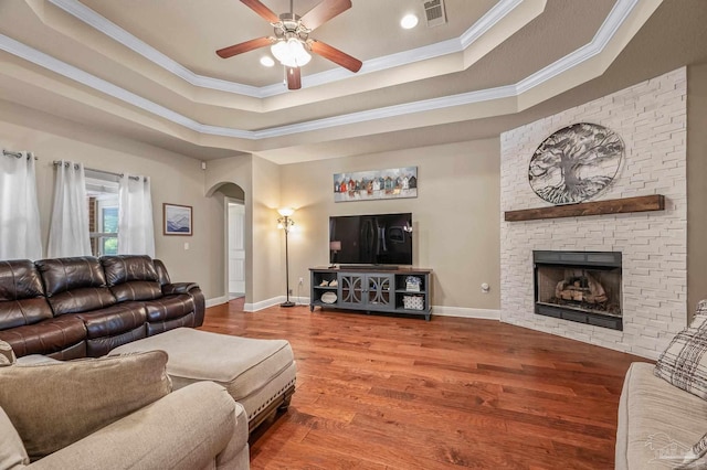 8847 Salt Grass Dr, Pensacola, FL 32526 - living room featuring arched walkways, wood finished floors, a tray ceiling, visible vents, and ornamental molding