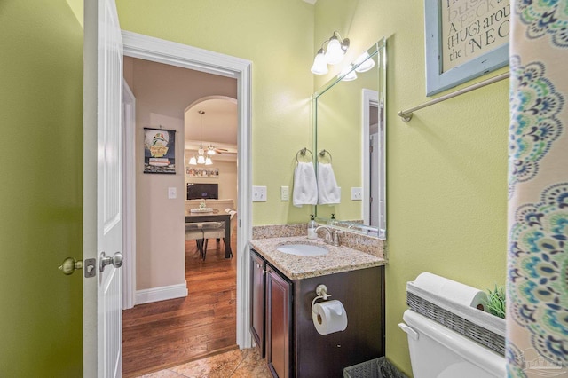 8847 Salt Grass Dr, Pensacola, FL 32526 - bathroom with vanity, wood finished floors, toilet, baseboards, and a notable chandelier