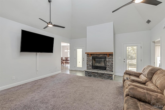 carpeted living room with ceiling fan, a fireplace, and high vaulted ceiling