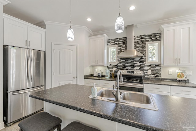 kitchen with pendant lighting, a breakfast bar, white cabinets, wall chimney exhaust hood, and stainless steel appliances