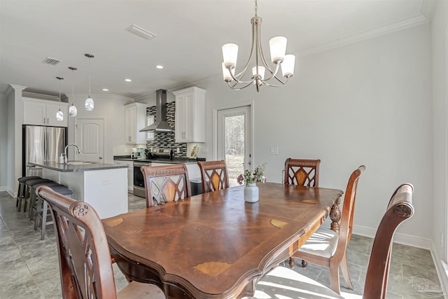 dining area featuring sink, ornamental molding, and a notable chandelier