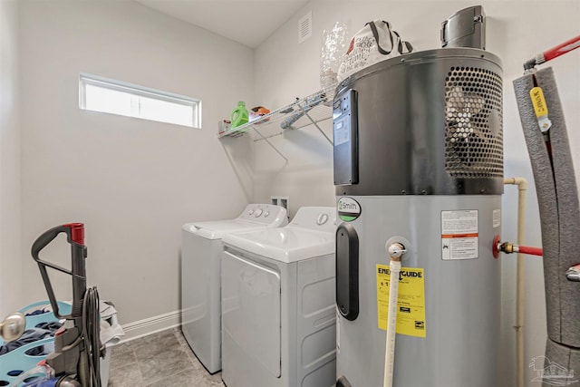 clothes washing area featuring hybrid water heater and separate washer and dryer