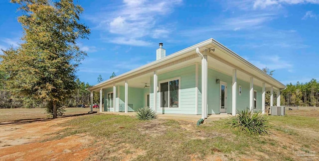 back of house featuring a porch, a yard, and cooling unit