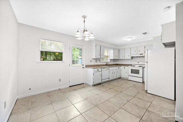 kitchen with white appliances, a chandelier, under cabinet range hood, and light tile patterned floors