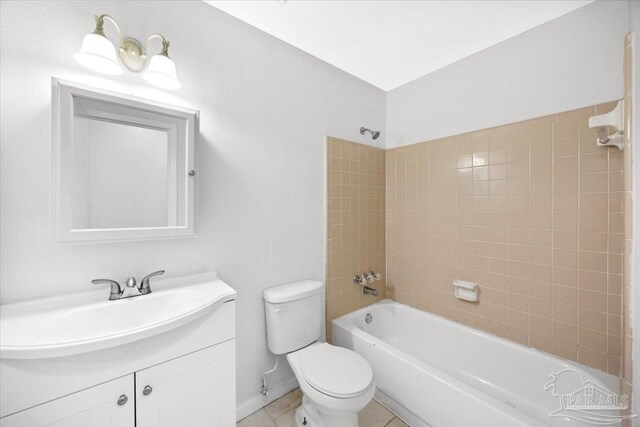 bathroom with toilet, bathing tub / shower combination, vanity, baseboards, and tile patterned floors