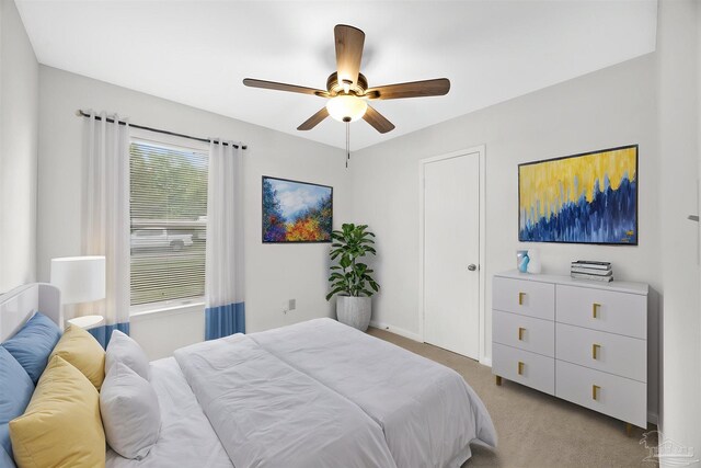 bedroom featuring light carpet, a ceiling fan, and baseboards