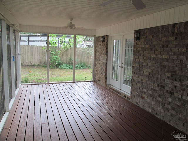 unfurnished sunroom with a ceiling fan, french doors, and healthy amount of natural light