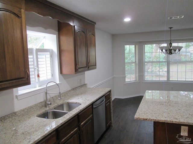 kitchen with stainless steel dishwasher, a sink, dark wood finished floors, a chandelier, and light stone counters