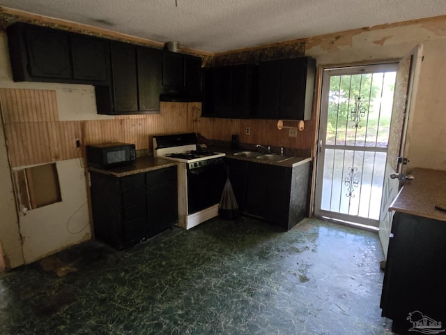 35 N Cypress St, Mcdavid, FL 32568 - kitchen featuring gas range, black microwave, ventilation hood, a sink, and wooden walls