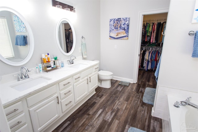 bathroom with vanity, a tub to relax in, toilet, and hardwood / wood-style floors