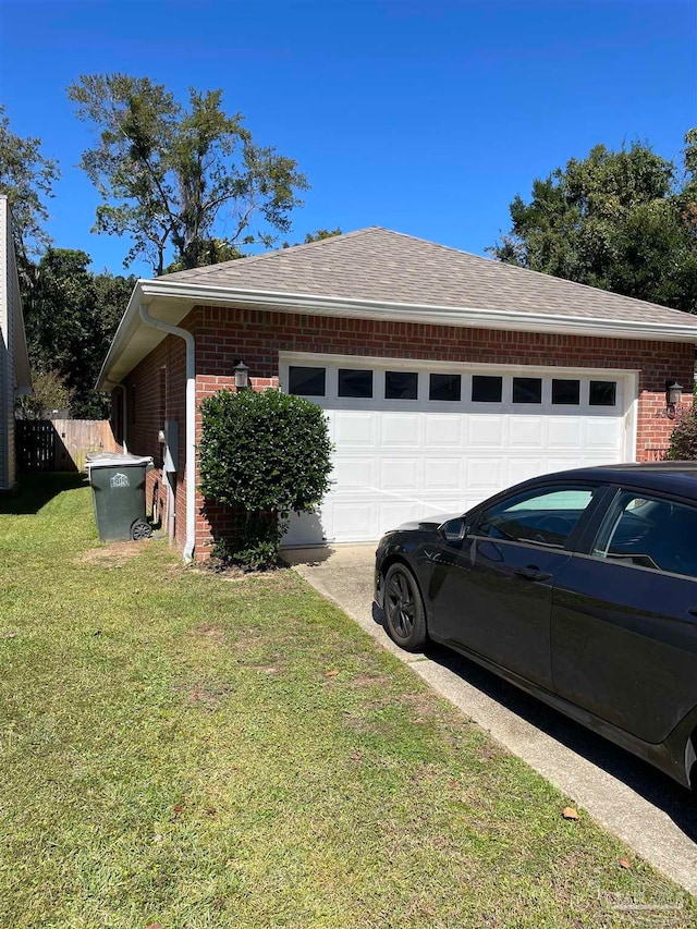 view of side of property featuring a garage and a lawn