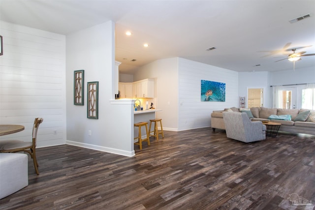 living room with ceiling fan and dark hardwood / wood-style flooring