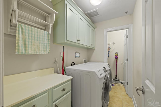 laundry area with visible vents, cabinet space, light tile patterned floors, and washer and dryer