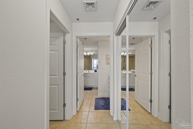 hall with light tile patterned floors and visible vents