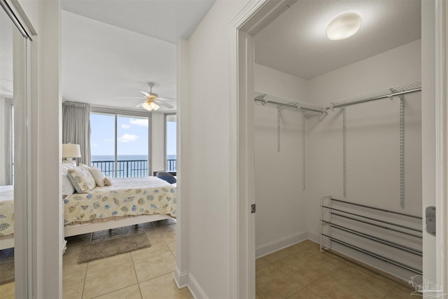 walk in closet featuring tile patterned flooring and a ceiling fan