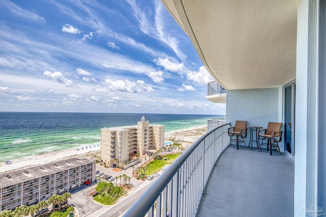 balcony featuring a water view and a view of the beach