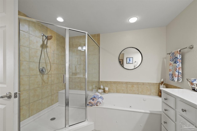 bathroom with a bath, vanity, and a stall shower
