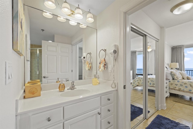 ensuite bathroom featuring a stall shower, ensuite bathroom, vanity, and tile patterned flooring