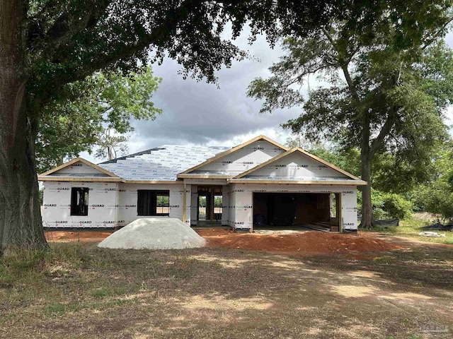 unfinished property featuring an attached garage and driveway
