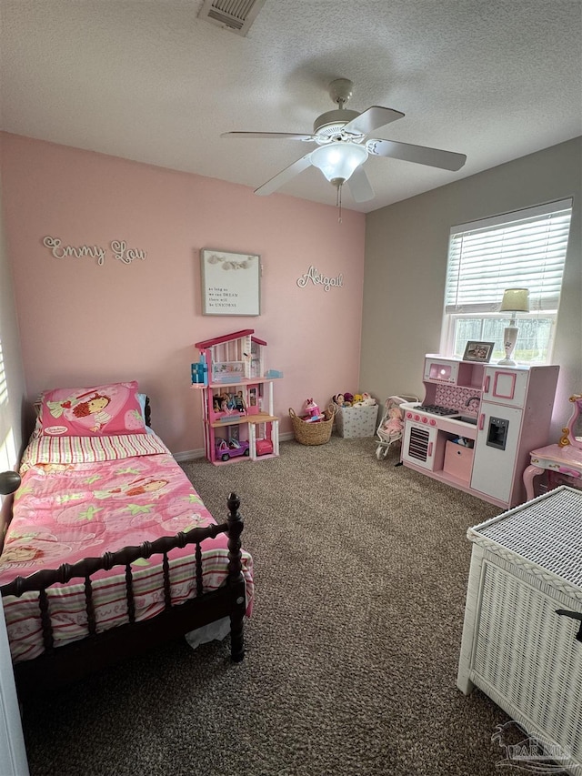 carpeted bedroom featuring a textured ceiling, visible vents, and a ceiling fan
