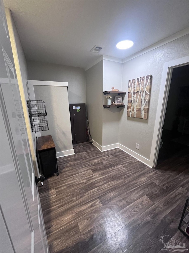 interior space featuring dark wood finished floors, visible vents, and baseboards