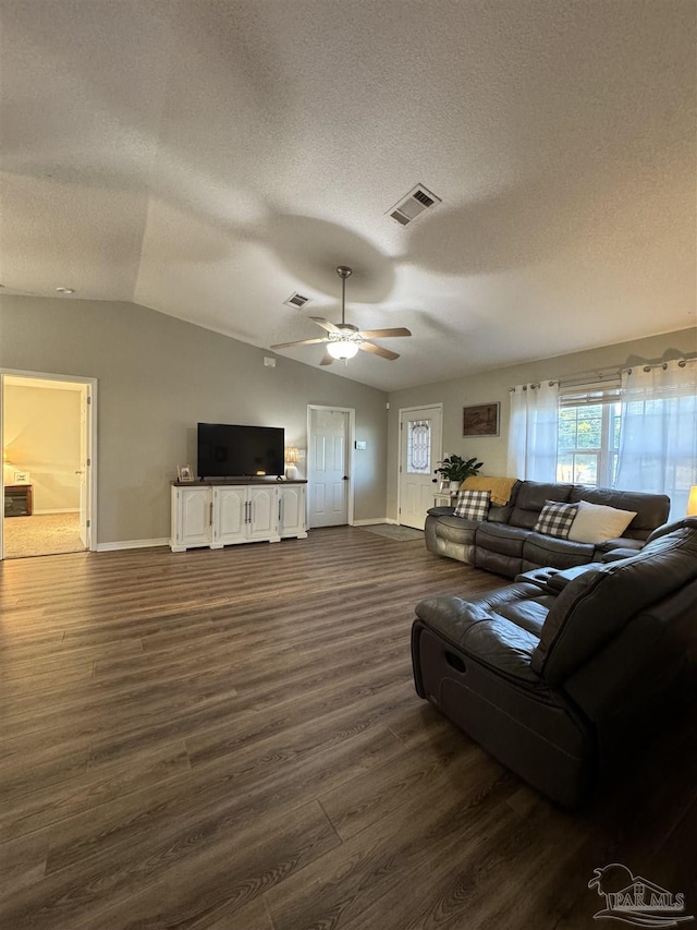 living room with lofted ceiling, a textured ceiling, visible vents, baseboards, and dark wood finished floors