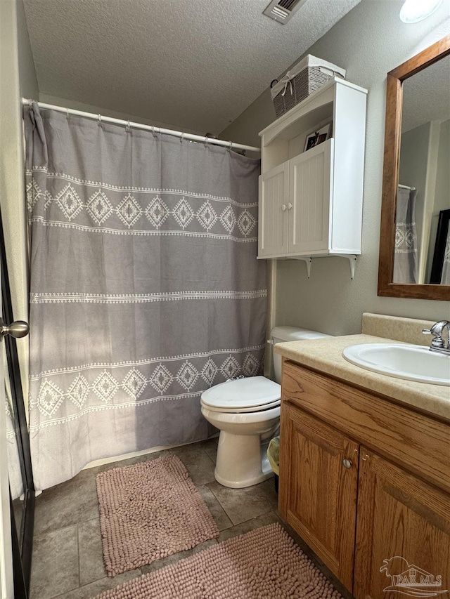 bathroom featuring toilet, a textured ceiling, visible vents, and vanity