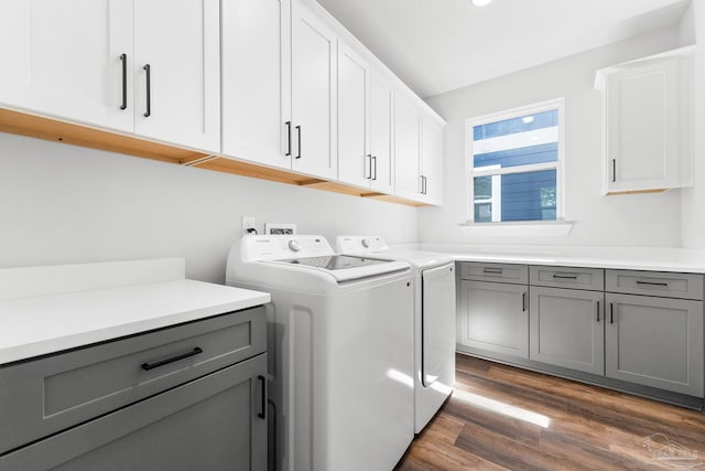 laundry room featuring cabinets, dark hardwood / wood-style flooring, and independent washer and dryer