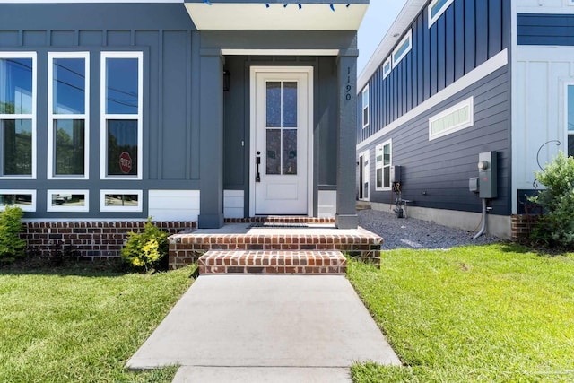 property entrance featuring a lawn