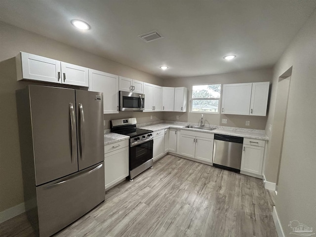 kitchen with stainless steel appliances, sink, and white cabinets