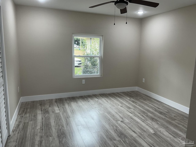 empty room with ceiling fan and light hardwood / wood-style flooring