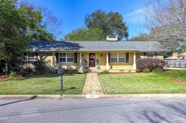 single story home featuring brick siding, a shingled roof, fence, a front yard, and a chimney