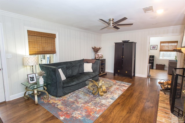 living area with ceiling fan, visible vents, wood finished floors, and crown molding