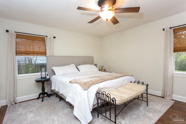 bedroom featuring a ceiling fan, baseboards, and wood finished floors