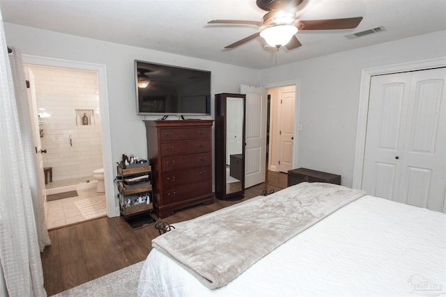 bedroom with wood finished floors, visible vents, ensuite bath, ceiling fan, and a closet