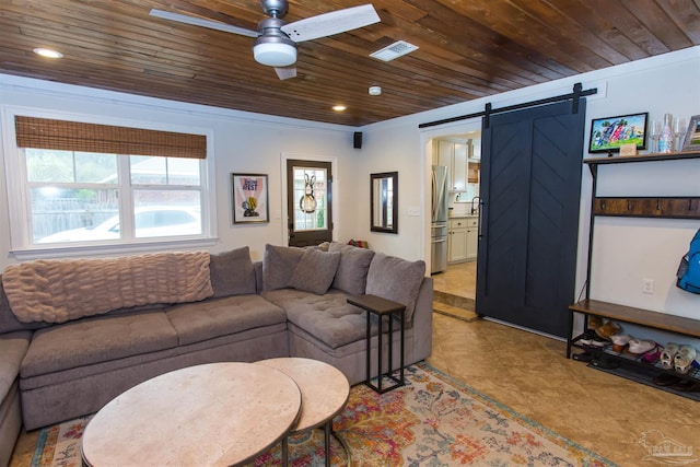 living room with a barn door, visible vents, wooden ceiling, and ceiling fan