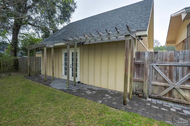 exterior space with a shingled roof, fence, french doors, a yard, and a pergola