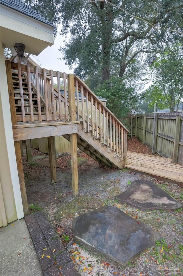 wooden terrace featuring stairs and fence