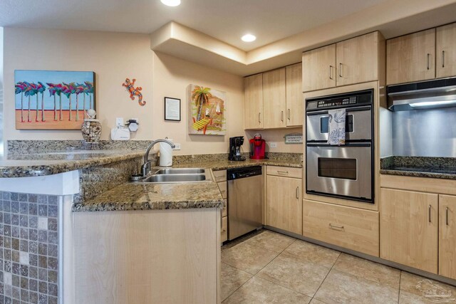 521 W Beach Blvd Unit 702, Gulf Shores, AL 36542 - kitchen with a peninsula, appliances with stainless steel finishes, a sink, and light brown cabinetry